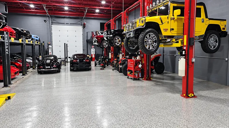 Vehicles raised on lifts along the walls of an automotive garage